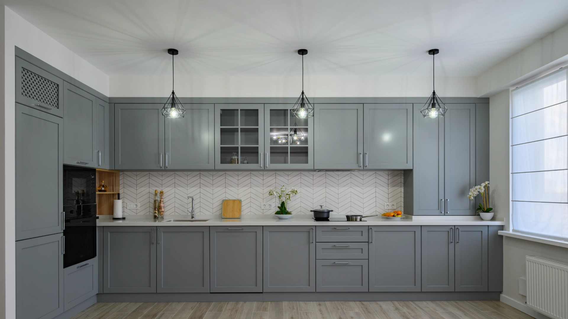Modern kitchen with gray cabinets and lighting.