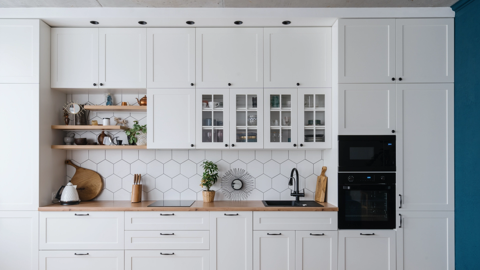 Modern kitchen with white cabinets and shelves.